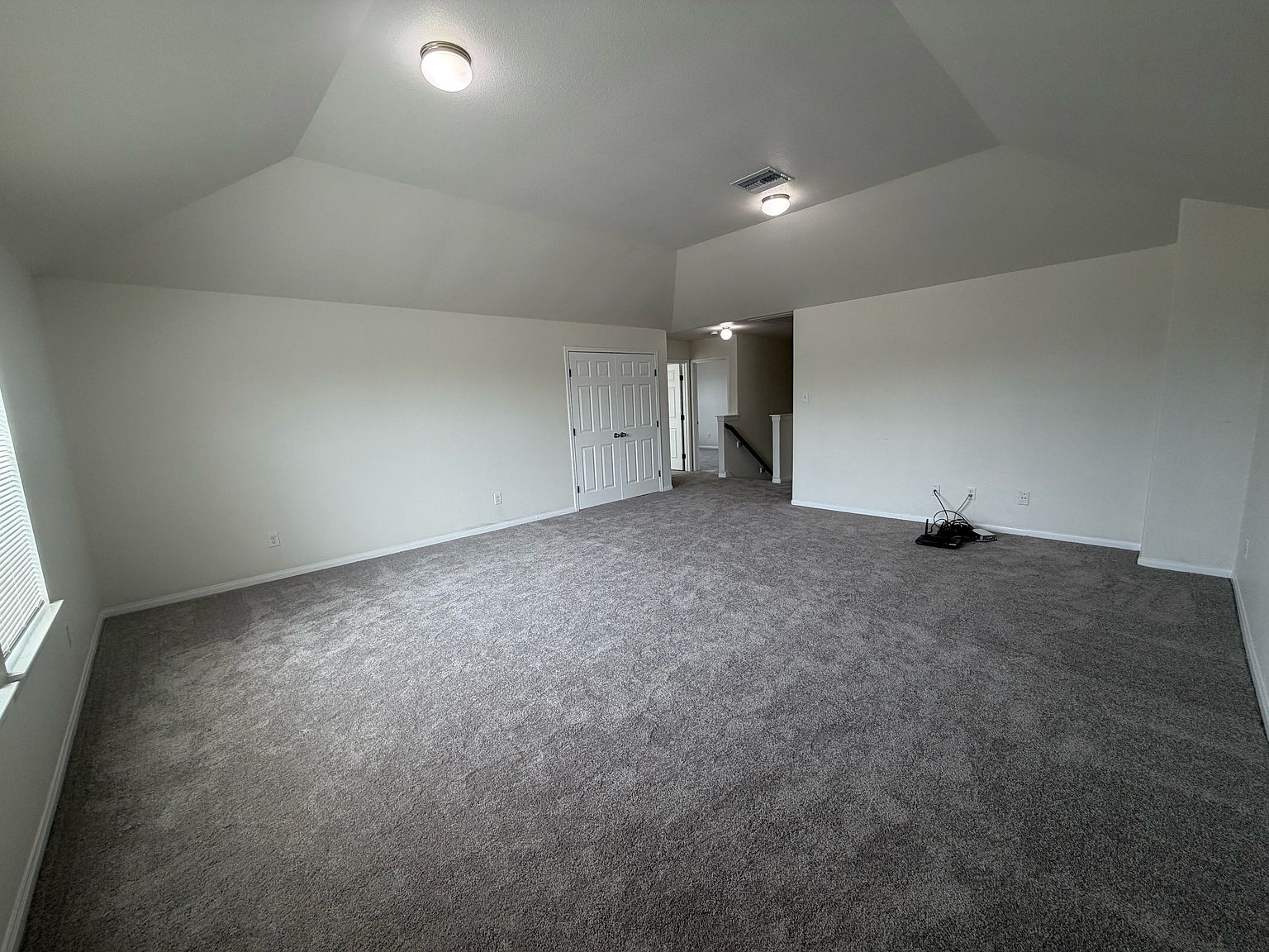 Upstairs game room with vaulted ceiling